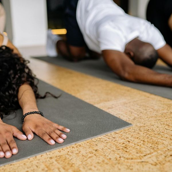 Group of diverse people preparing for a yoga class in a sunlit studio.